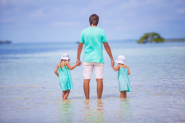 Vista posteriore del giovane padre e le sue due adorabili figlie in una vacanza esotica