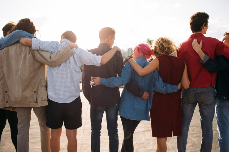 Vista posteriore del gruppo di giovani diversi. Braccio intorno. Sostegno all'unità. Amicizia insieme