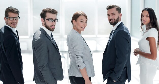 Vista posteriore del team di business sorridente e guardando il concetto di business della fotocamera