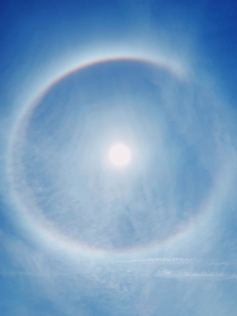 Vista posteriore dell'arcobaleno intorno al sole. Sfondo chiaro cielo blu