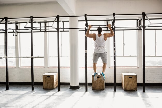 Vista posteriore dell&#39;uomo muscolare facendo pull ups