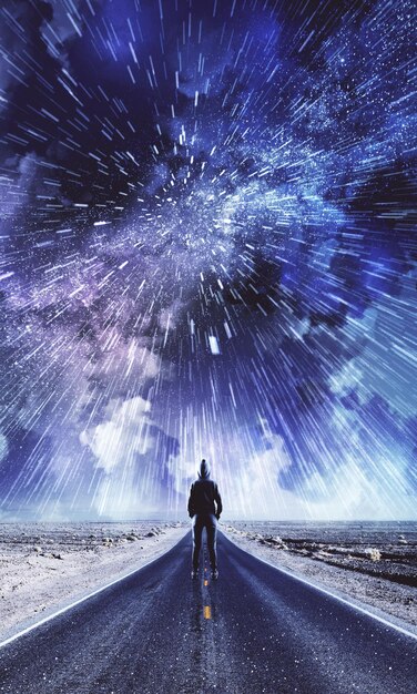 Vista posteriore dell'uomo su strada creativa con sfondo del cielo notturno nuvoloso Concetto di libertà e opportunità
