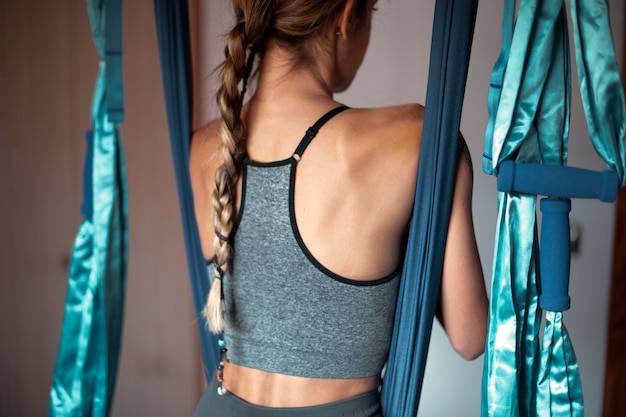 Vista posteriore della donna che fa yoga a casa