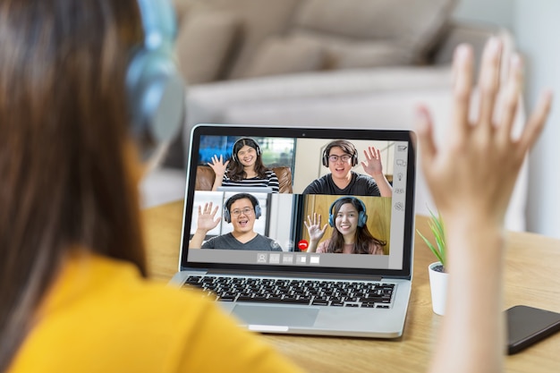 Vista posteriore della donna d'affari asiatica saluta con un collega di lavoro di squadra in videoconferenza