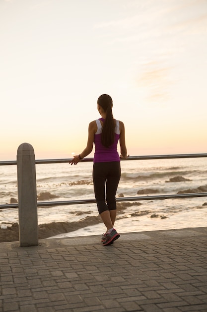 Vista posteriore della donna in forma in piedi a ringhiera