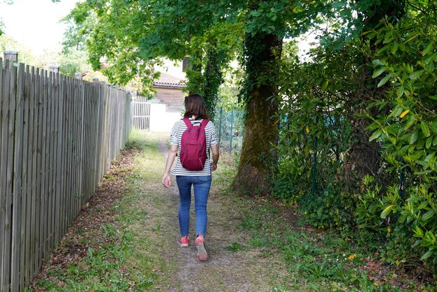 vista posteriore della donna nel percorso del parco a piedi a Saint Medard en jalles Francia