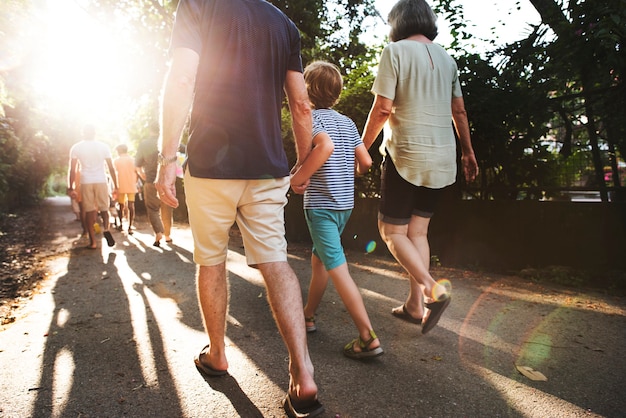 Vista posteriore della famiglia caucasica che cammina insieme all'aperto