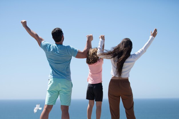 Vista posteriore della famiglia spensierata in vacanza al mare