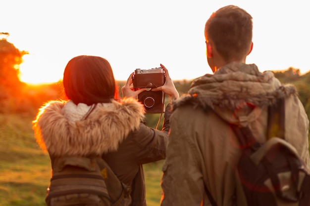 Vista posteriore della giovane coppia a scattare foto in vacanza