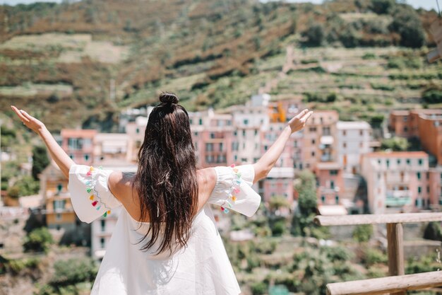 Vista posteriore della ragazza felice sfondo bella vista di Manarola, Cinque Terre, Liguria, Italia