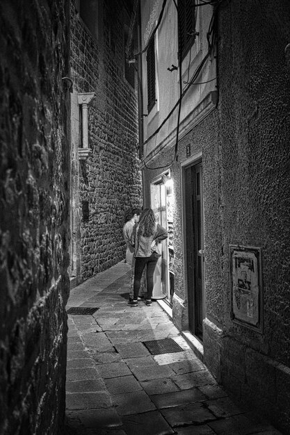 Vista posteriore di donne in piedi fuori dal negozio in città di notte