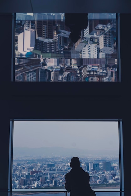 Vista posteriore di edifici contro il cielo vista attraverso una finestra di vetro