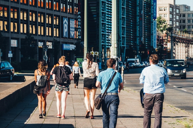 Vista posteriore di persone che camminano contro gli edifici in città