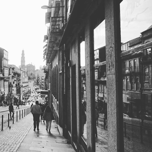 Vista posteriore di persone che camminano per strada tra gli edifici della città
