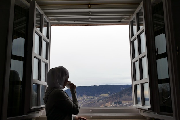 Vista posteriore di persone che guardano attraverso la finestra