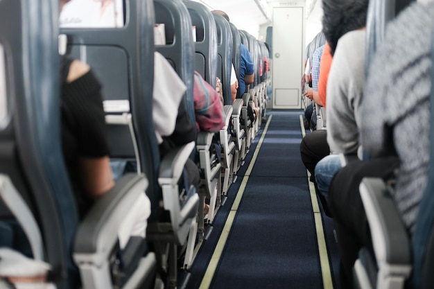 Vista posteriore di persone sedute su sedie in treno