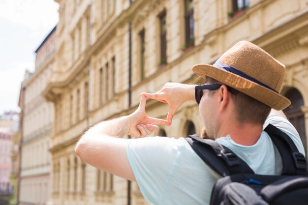 Vista posteriore di un giovane turista che scatta foto di fronte alla città