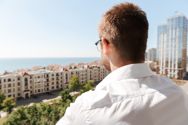 Vista posteriore di un giovane uomo in piedi su un balcone