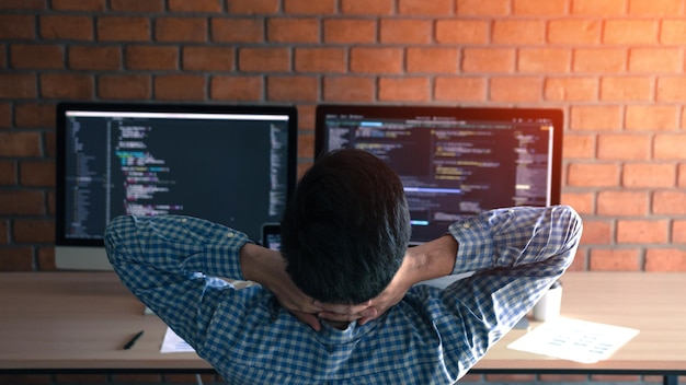 Vista posteriore di un programmatore di computer che codifica in ufficio
