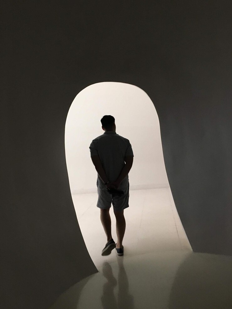 Foto vista posteriore di un uomo a silhouette appoggiato al muro