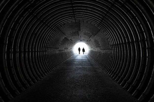 Vista posteriore di un uomo a silhouette che cammina nel tunnel