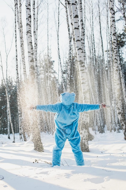 Vista posteriore di un uomo adulto in piedi su un campo coperto di neve nella foresta