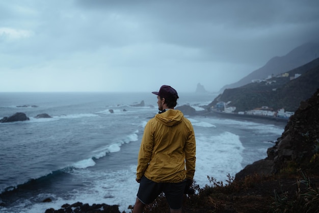 Vista posteriore di un uomo che guarda il mare contro il cielo