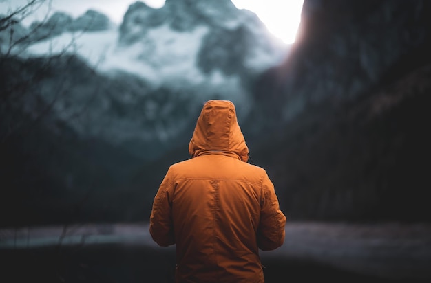 Vista posteriore di un uomo che guarda la montagna durante l'inverno