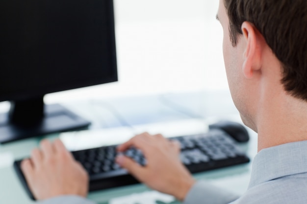 Vista posteriore di un uomo d&#39;affari che lavora con un monitor