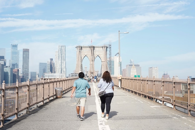 Vista posteriore di un uomo e di una donna che camminano su un ponte in città