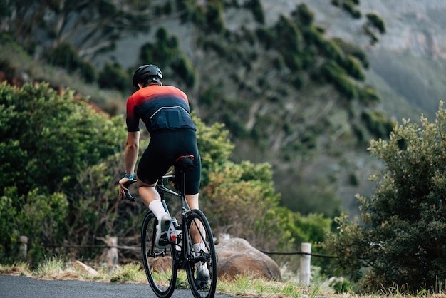 Vista posteriore di un uomo in bicicletta sulla montagna