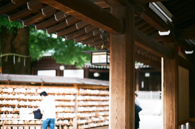 Vista posteriore di un uomo in piedi vicino ai blocchi di preghiera al santuario meiji-jingu