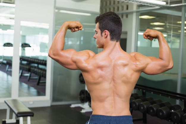 Vista posteriore di un uomo muscoloso che flette i muscoli