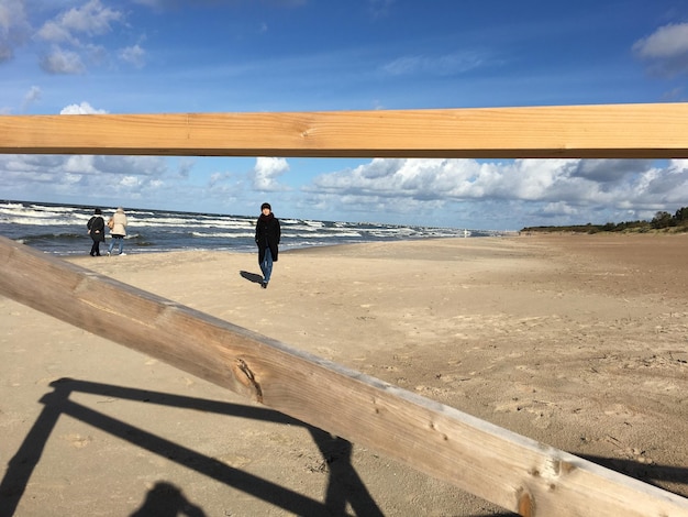 Vista posteriore di un uomo sulla spiaggia contro il cielo