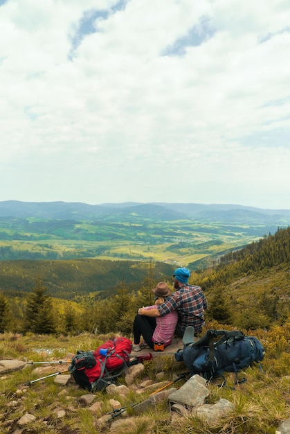 Vista posteriore di una coppia seduta sulla montagna