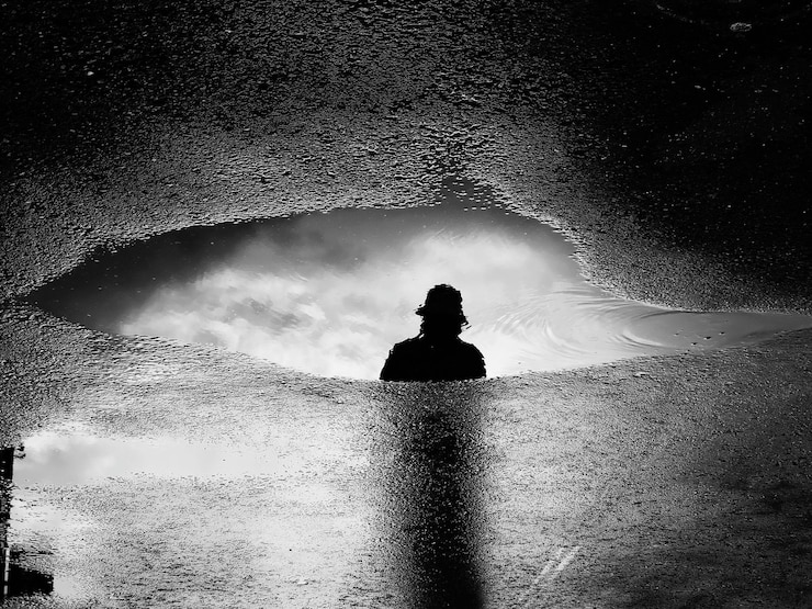 Foto vista posteriore di una donna a silhouette in piedi sulla spiaggia contro il cielo