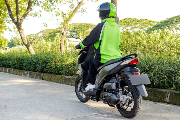 Vista posteriore di una donna asiatica che lavora come tassista motociclista