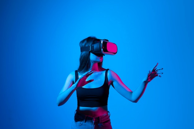 Vista posteriore di una donna che fotografa sullo sfondo blu