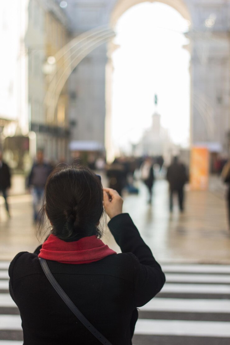 Foto vista posteriore di una donna che fotografa un edificio storico