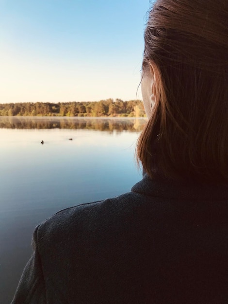 Vista posteriore di una donna che guarda il lago