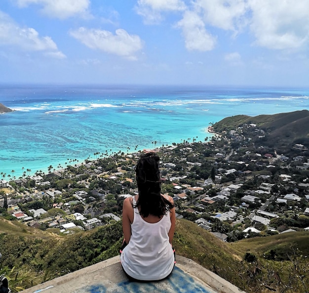 Vista posteriore di una donna che guarda il mare contro il cielo