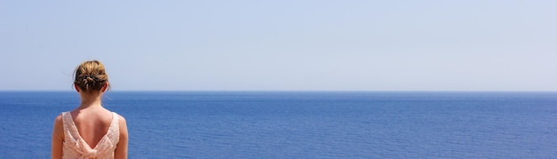 Vista posteriore di una donna che guarda il mare