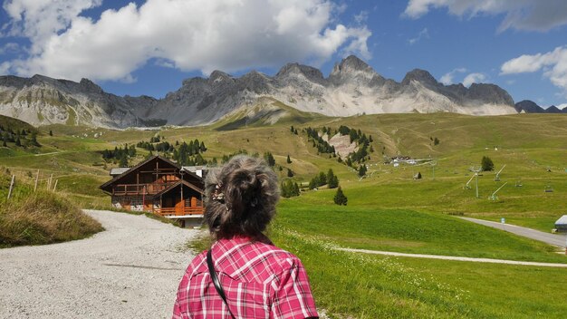 Vista posteriore di una donna che guarda le montagne contro il cielo