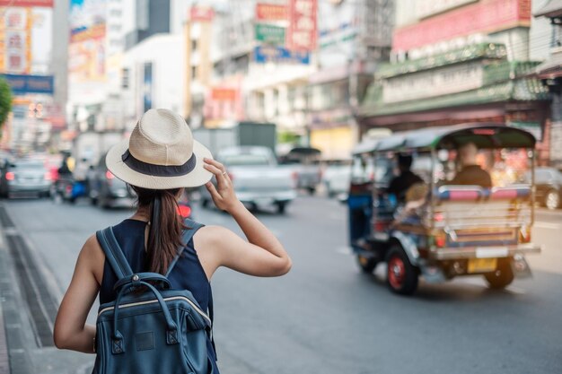 Vista posteriore di una donna che indossa un cappello da veicoli in strada in città