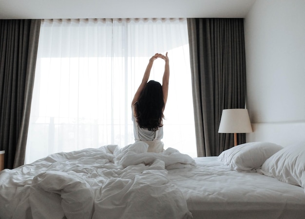 Vista posteriore di una donna che si rilassa a letto a casa