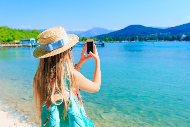 Vista posteriore di una donna con il telefono in mano e foto belle