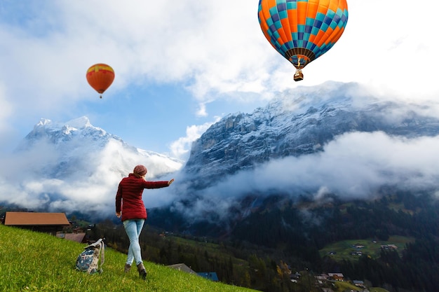 Vista posteriore di una donna con palloncini ad aria calda contro il cielo
