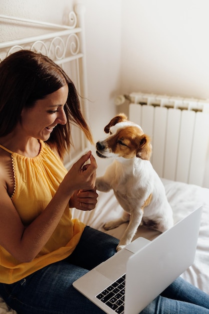 Vista posteriore di una donna con un cane seduta a casa