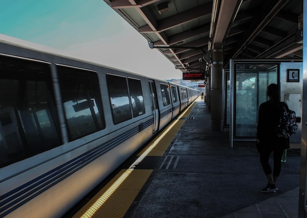 Vista posteriore di una donna in piedi alla stazione ferroviaria