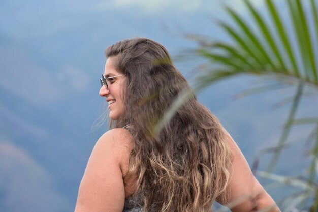 Vista posteriore di una donna in piedi contro le montagne